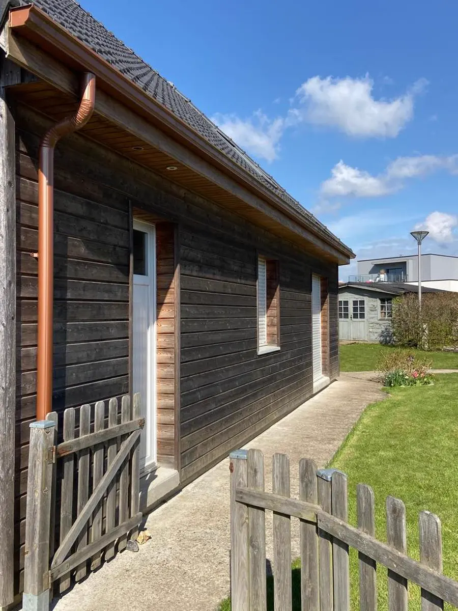 Façade latérale en bardage bois grisé, avec descente de gouttière cuivrée, avant rénovation à L'Haÿ-les-Roses